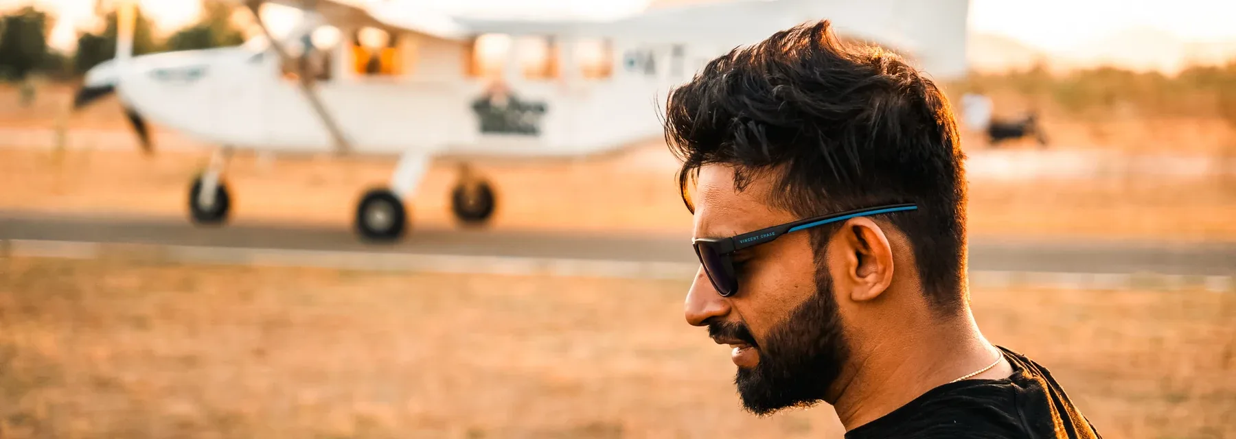 Anubhav at the dropzone with the jump aircraft behind him